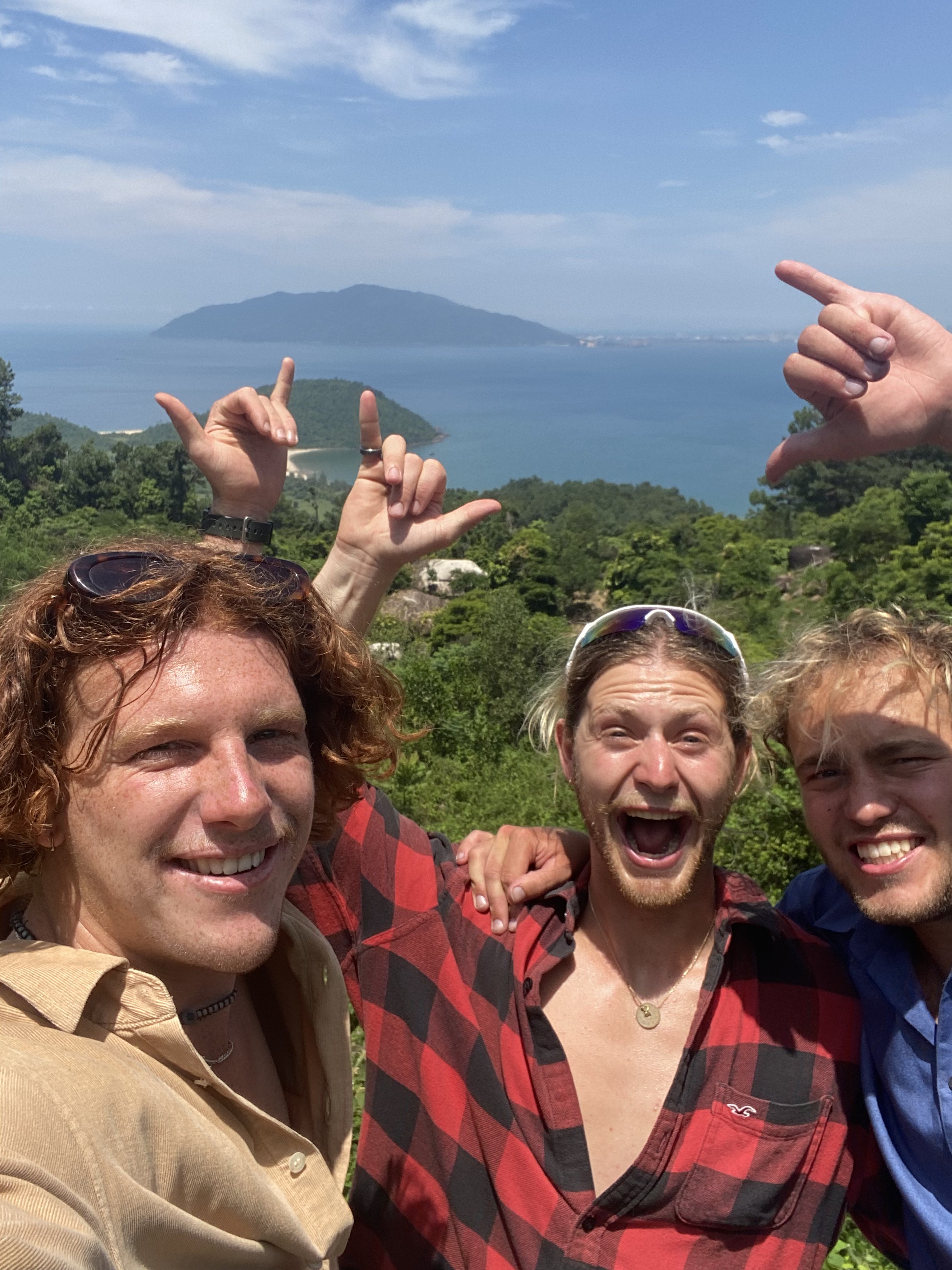 Fin and the crew cheering on a headland above a tropical coastline